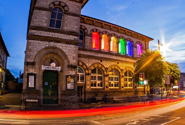 Midsomer Norton Town Hall at night lit up in Pride colours